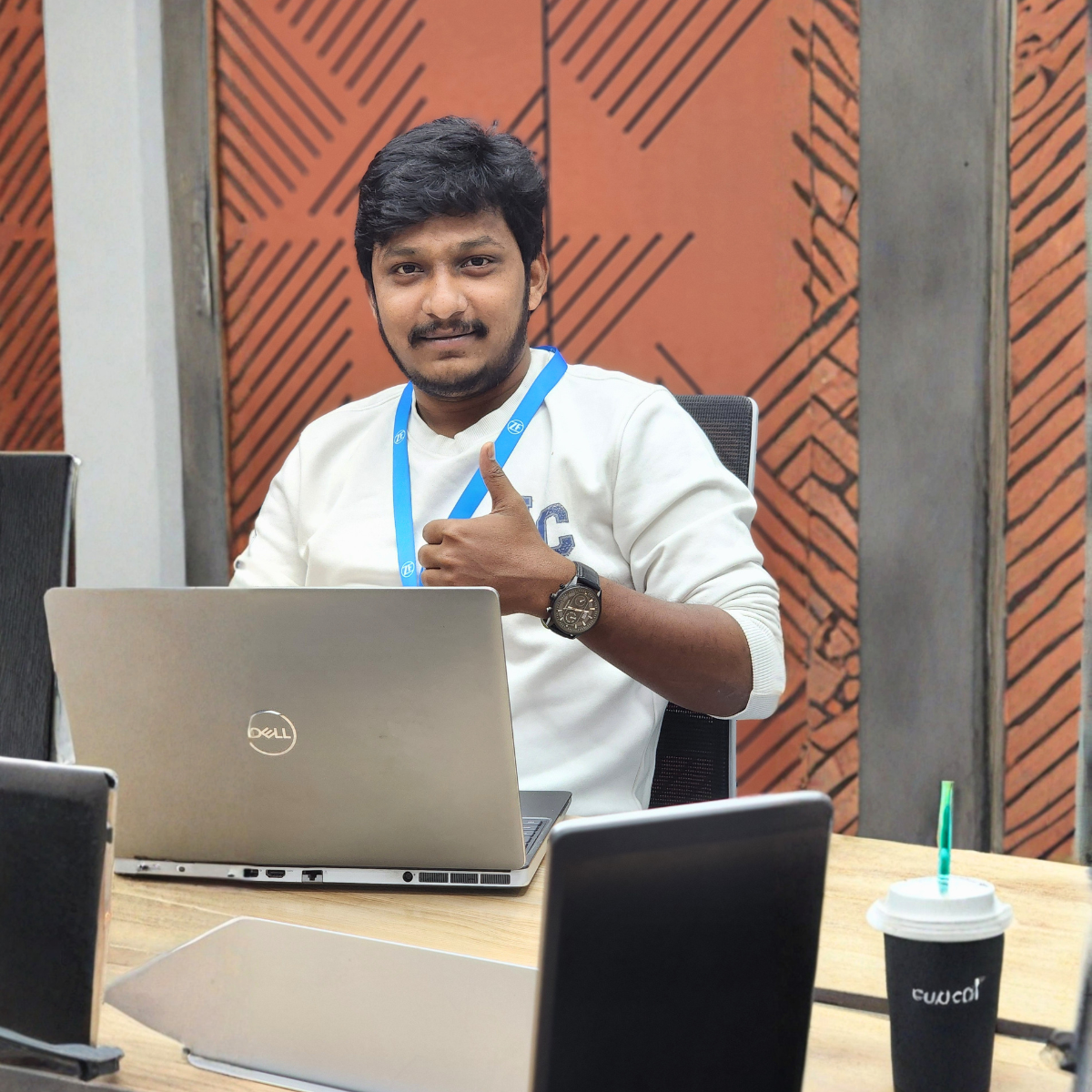 ZF alumnus seated at a workstation with a laptop, featured in the Where We Belong alumni program success stories.
