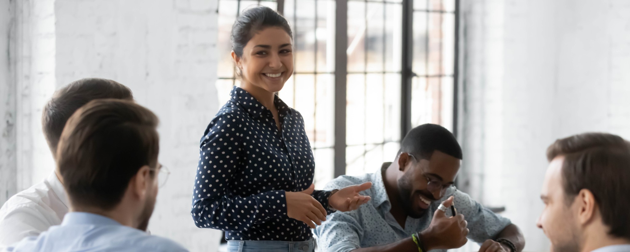 Five people around a desk, smiling and laughing
