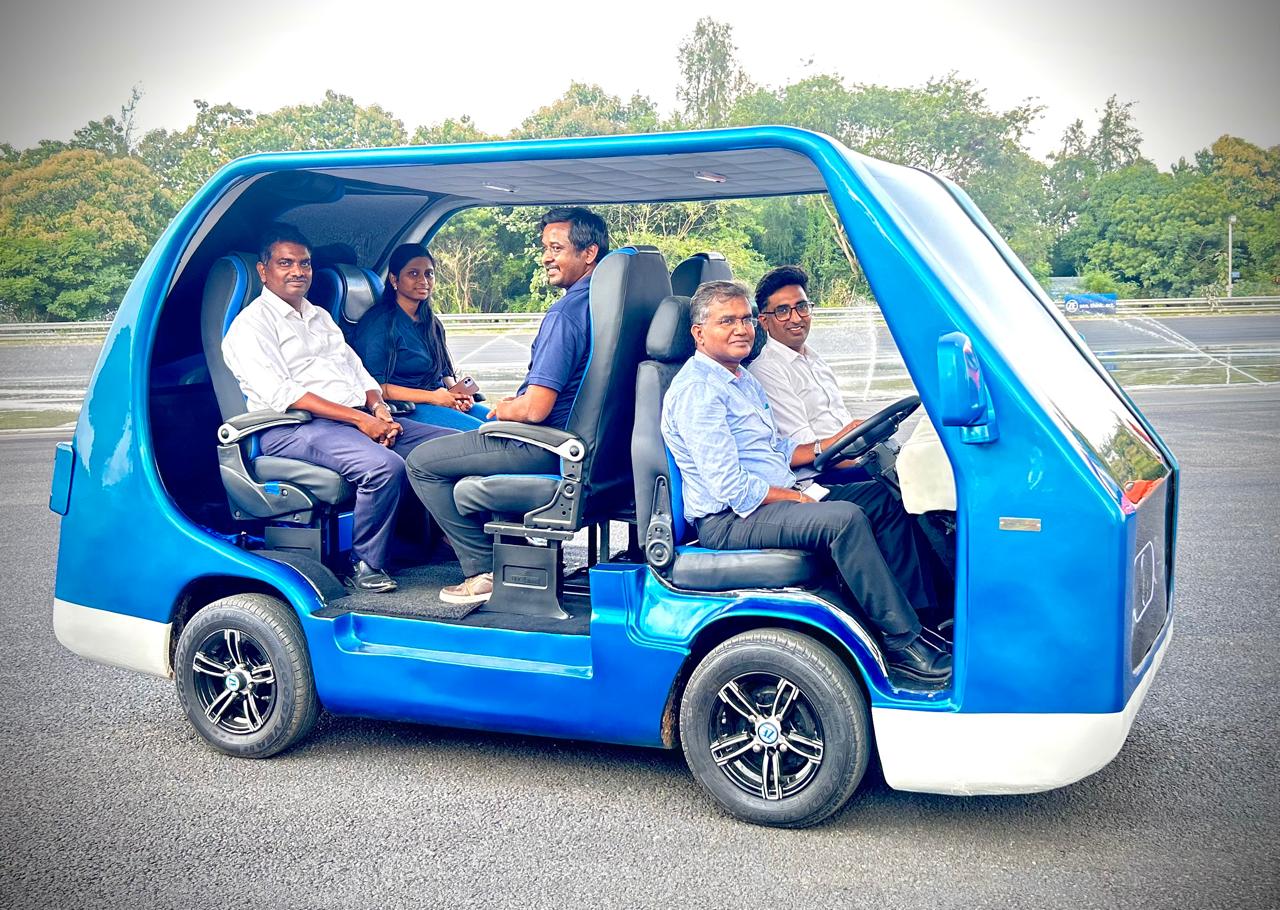 Employees seated inside a compact autonomous-style blue vehicle, showcasing innovation in mobility technology at ZF Group.