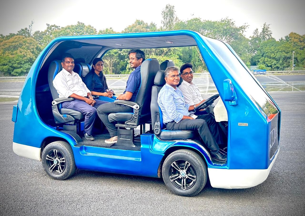 Employees seated inside a compact autonomous-style blue vehicle, showcasing innovation in mobility technology at ZF Group.