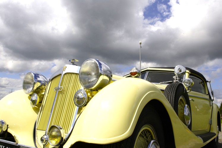 Das Bild zeigt einen gelben Horch 853 von vorne im Anschnitt.