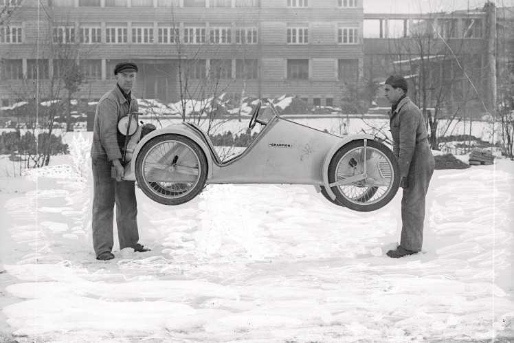 Auf einem Bild in schwarz-weiss stehen zwei Männer auf dem ZF-Werksgelände im Schnee und halten einen Champion hoch.