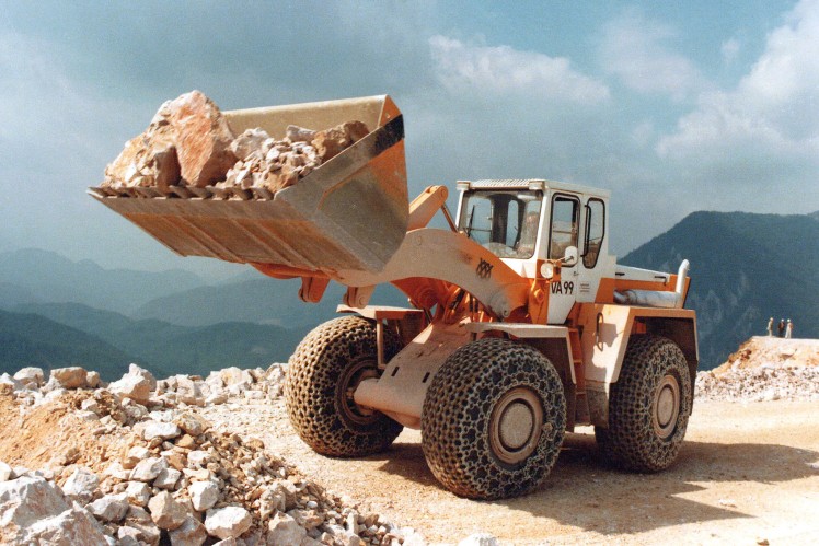Das Farbbild zeigt einen Voeest-Alpine-Radlader im Steinbruch mit aufgestellter Lade.