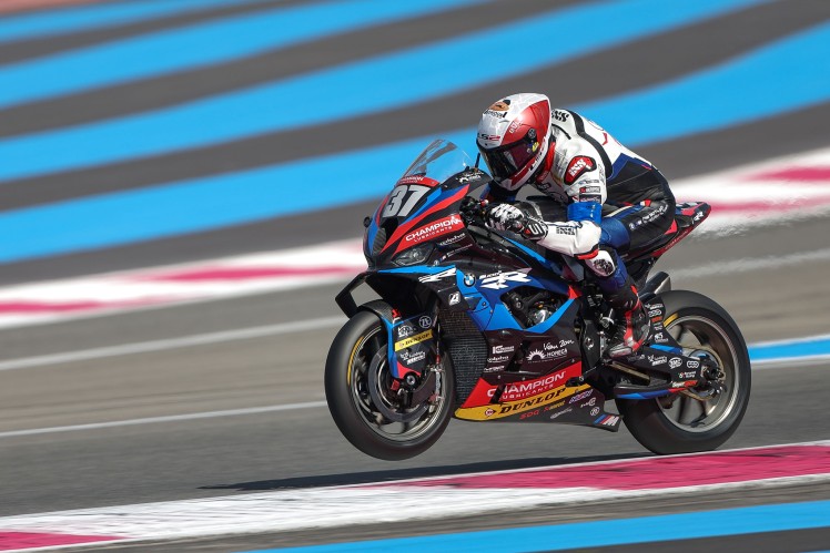 Person on motorbike travelling at speed on race track.