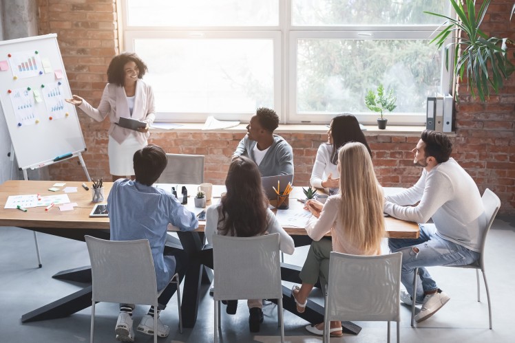 People sitting round desk looking at flipchart