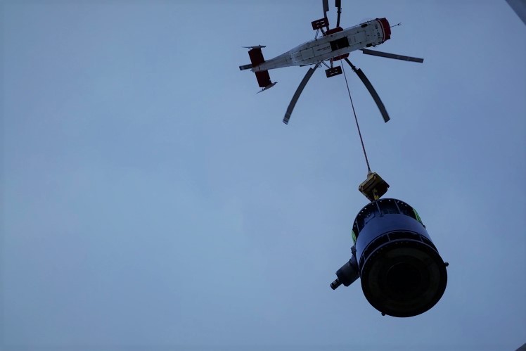 A helicopter transports a ropeway gearbox that need to be maintained.