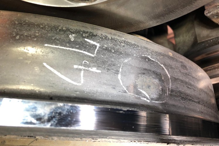 Wheel tire of a rail vehicle that has a flat spot that is circled in white.