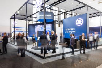 Mehrere Menschen in Aktion auf und vor dem ZF-Stand auf der InnoTrans 2024.