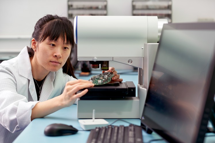 Engineer placing sample on microscope