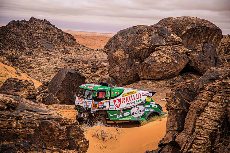 Off-road vehical travelling on uneven terrain and rocky background