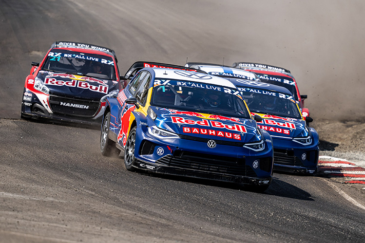 Four rally cars on the track travelling at speed