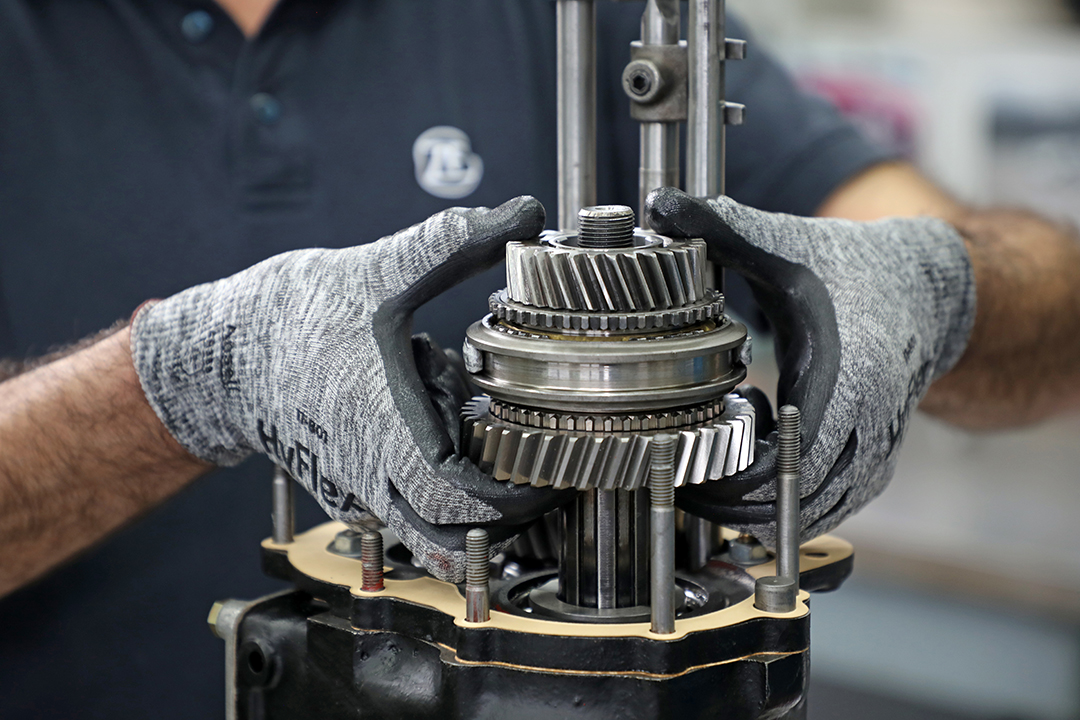 Automotive part held in two hands wearing gloves