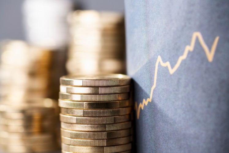 Stack of coins with line showing increasing cost